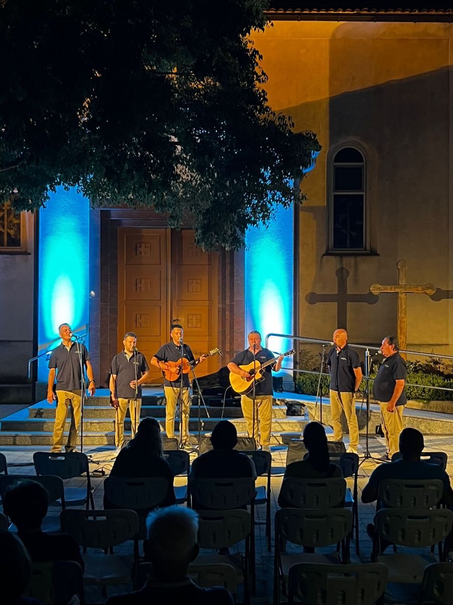 Klapa Rašketa pjeva uz gitaru na večernjem nastupu na otvorenom, pred publikom